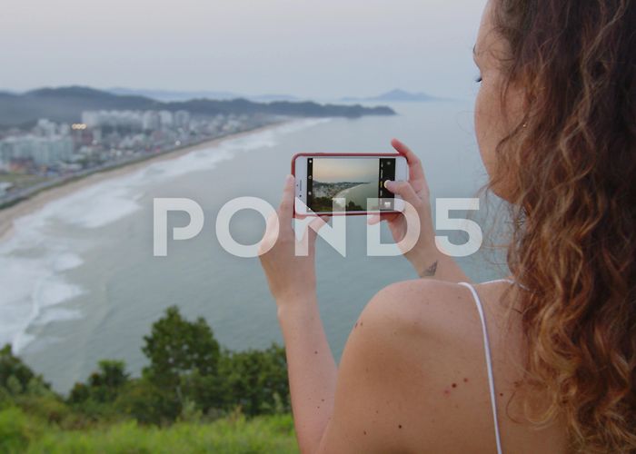 Careca Hill Brazilian girl taking pictures of sunset... | Stock Video | Pond5 photo